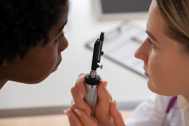 Free photo doctor checking patient's eye side view