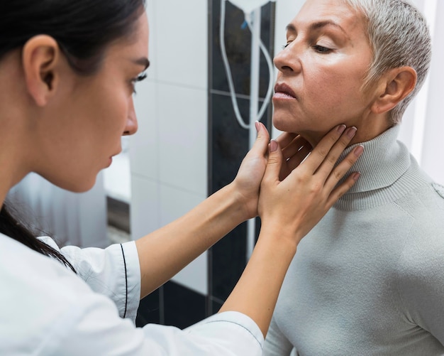 Free photo doctor checking a patient's neck