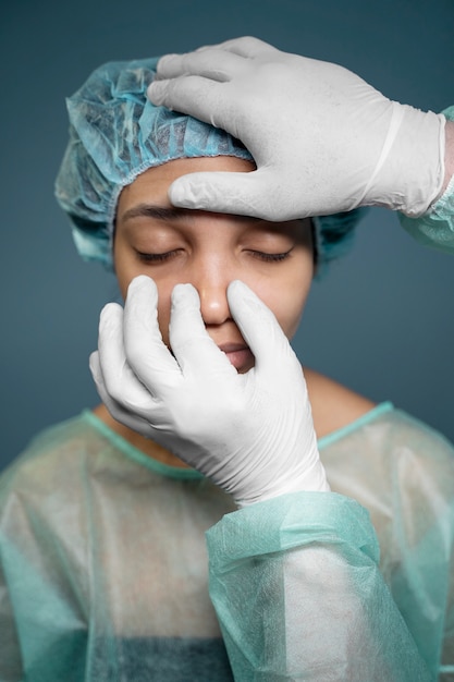 Free photo doctor checking patient's nose before surgery