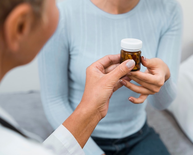 Doctor giving a bottle of pills to a patient