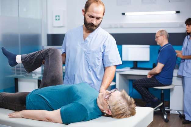 Free Photo doctor helping old woman with knee pain