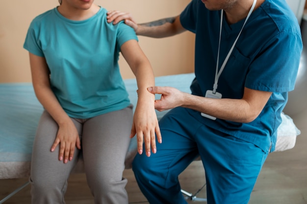 Doctor helping patient during rehabilitation