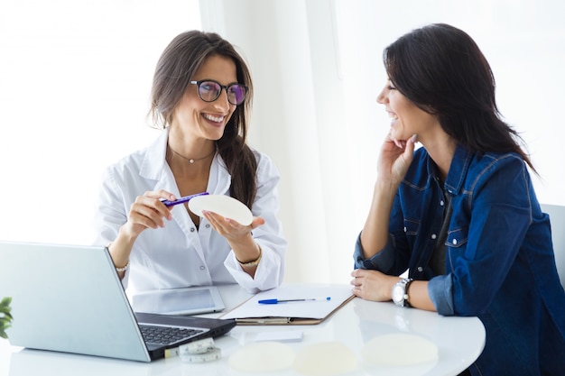 Free photo doctor and her patient choosing mammary prosthesis in the office.