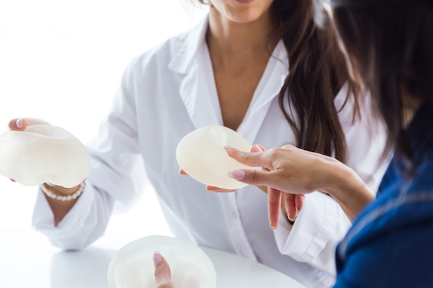 Doctor and her patient choosing mammary prosthesis in the office.