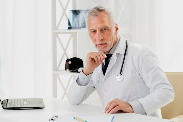 Doctor at his desk with hand on chin