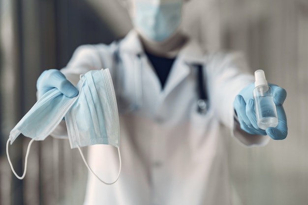 Free photo doctor hold the antiseptic and masks in his hand