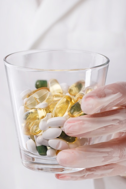 Doctor holding glass of pills