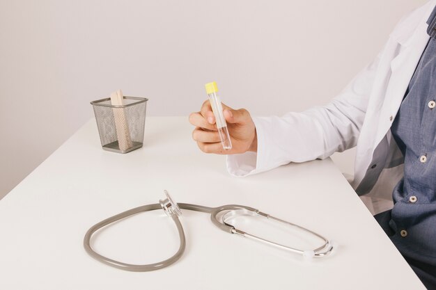 Doctor holding a medication at his desk