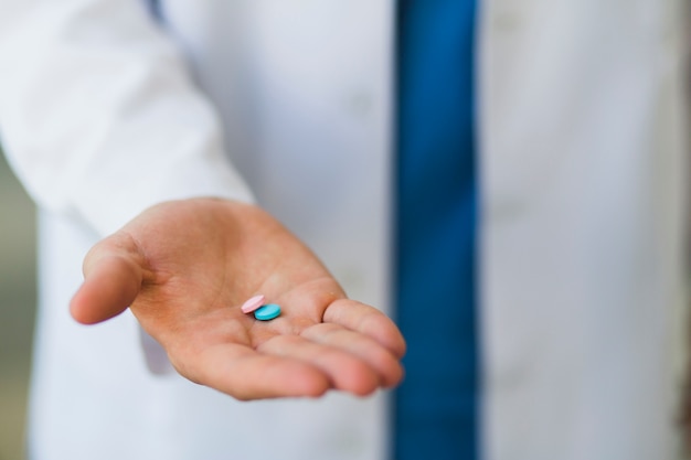 Doctor holding pills in hand