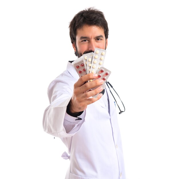 Doctor holding pills over white background