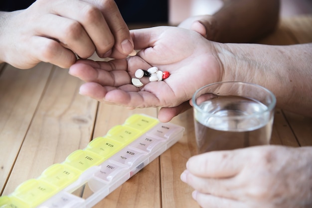 Free Photo doctor is assist patient to eat medicine tablet in pillbox correctly 