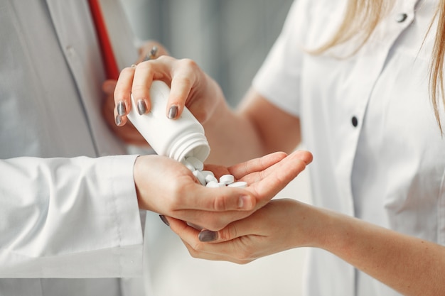 Free photo doctor is sharing pills in hands to another doctor