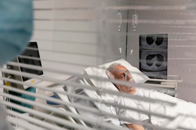 Free photo doctor looking at a patient through a window