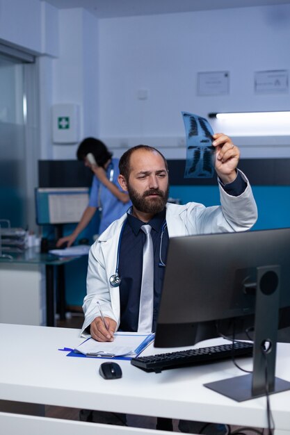 Doctor looking at x ray scan in hand for medical diagnosis