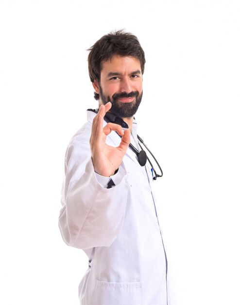 Doctor making Ok sign over white background