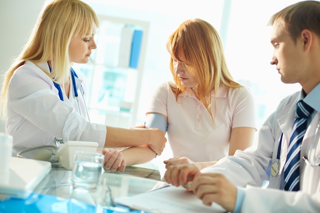 Doctor measuring blood pressure of patient