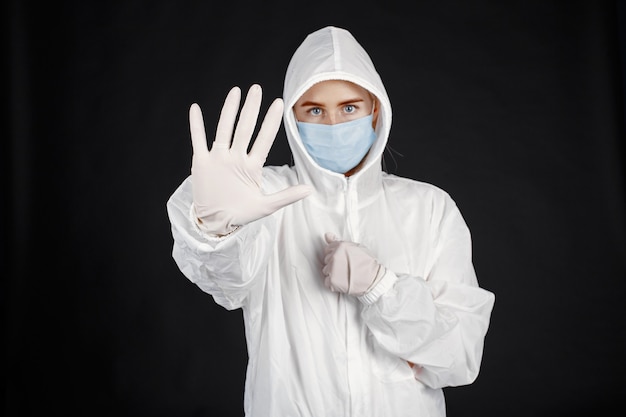 Free photo doctor in a medical mask. coronavirus theme. isolated over black wall. woman in a protective suit.