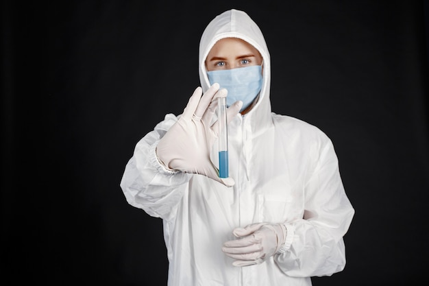 Doctor in a medical mask. Coronavirus theme. Isolated over black wall. Woman in a protective suit.