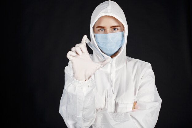 Doctor in a medical mask. Coronavirus theme. Isolated over white background. Woman in a protective suit.