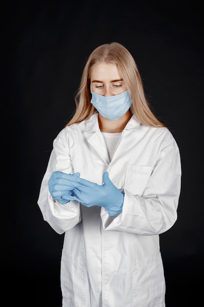 Doctor in a medical mask. Coronavirus theme. Isolated over white background. Woman in a protective suit.