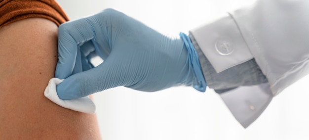 Free photo doctor putting pressure on man's arm after vaccinating