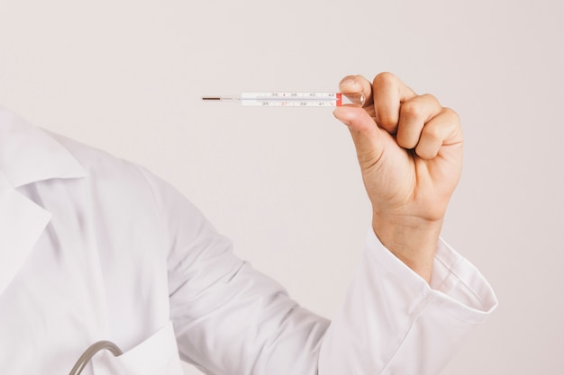 Free photo doctor's hand holding a thermometer