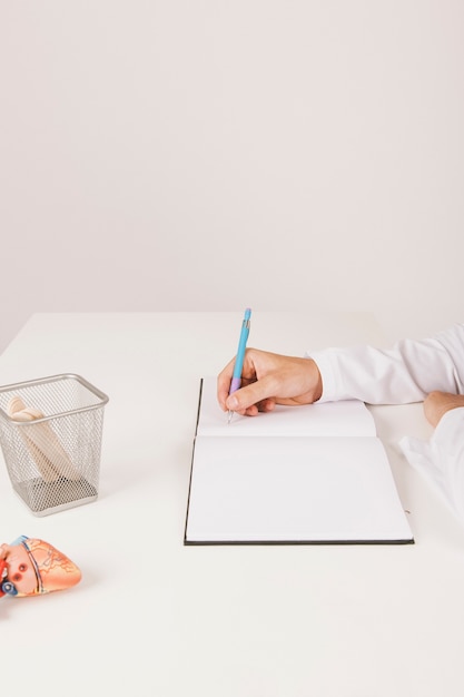 Free Photo doctor's hand writing on his notebook