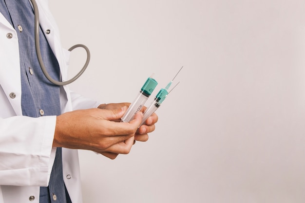 Doctor's hands with several syringes