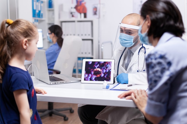 Free photo doctor showing how virus attaks immune system to mother and child during consultation