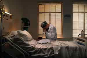 Free photo doctor sitting on a hospital bed while being sad