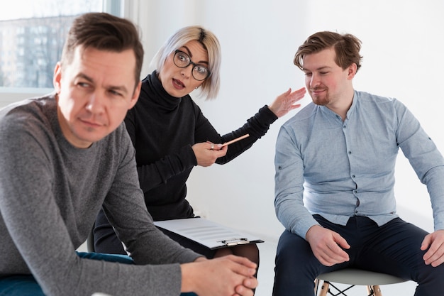 Free photo doctor sitting between male patients