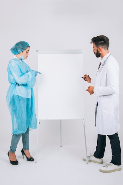 Doctor and surgeon at presentation with whiteboard