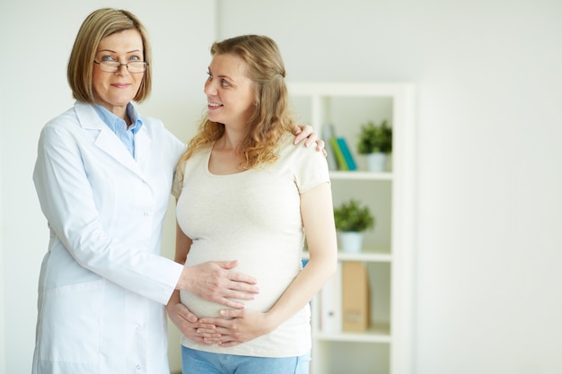 Free Photo doctor touching the belly of her patient