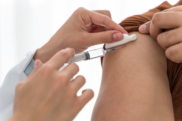 Free Photo doctor vaccinating a man close-up