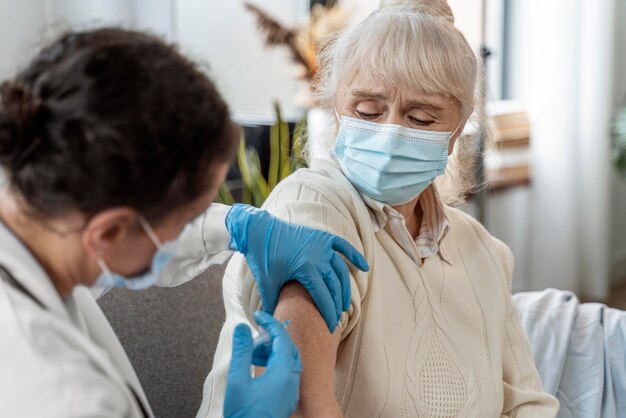 Doctor vaccinating a senior woman