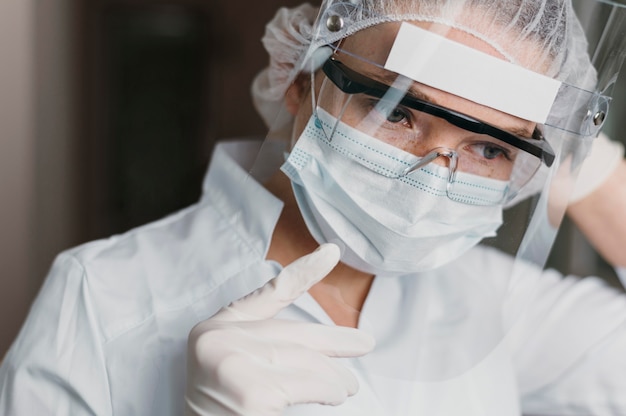 Free photo doctor wearing a face mask and protective goggles