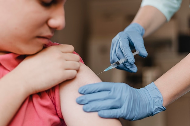 Doctor wearing gloves and giving kid a vaccine