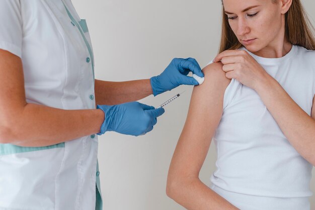 Doctor with gloves administering vaccine to woman