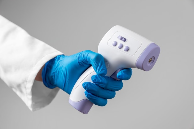 Doctor with gloves holding thermometer