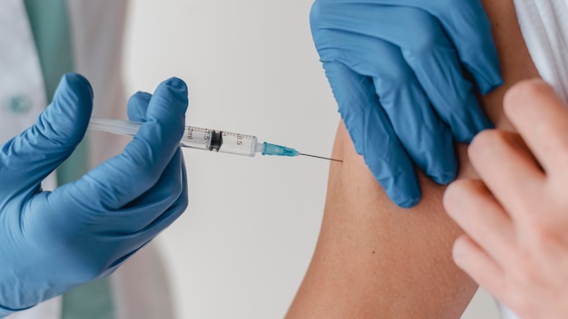 Doctor with gloves vaccinating patient