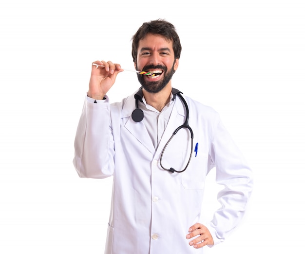 Doctor with lolly pop over white background