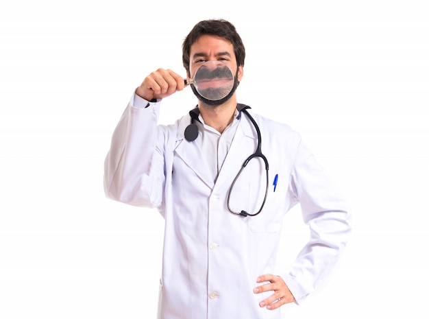 Doctor with magnifying glass over white background