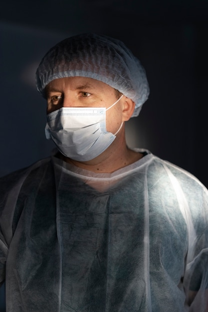 Doctor with mask in the dark