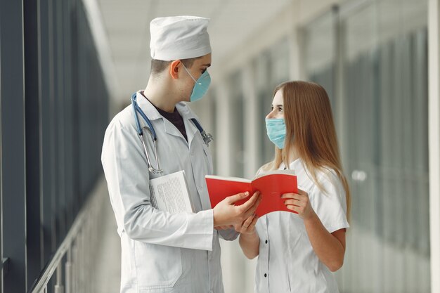 Doctors in masks are discussing the problem in a hall