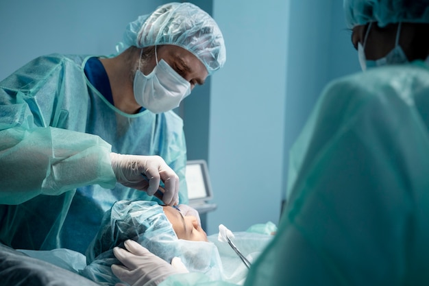 Free photo doctors performing rhinoplasty in operating room