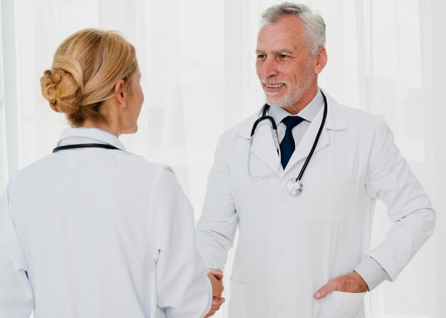 Doctors smiling and shaking hands 