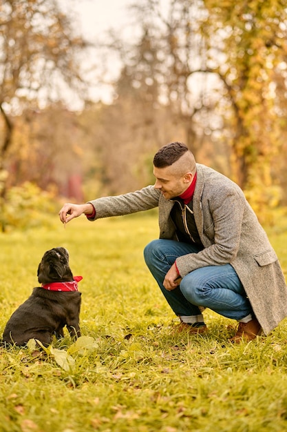 Free photo dog training. a man training his dog in the park