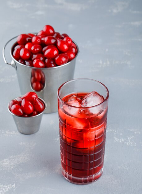 Dogwood berries with drink in buckets on plaster, high angle view.