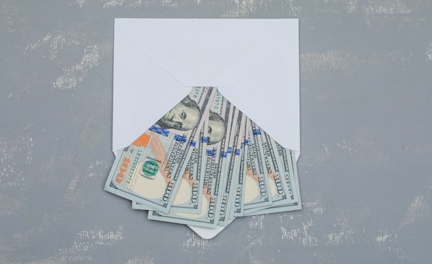 Free photo dollar banknotes in opened envelope on plaster table