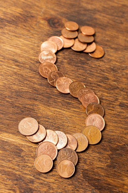 Free photo dollar sign made out of coins on wooden background